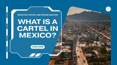 Aerial view of a Mexican city at sunset with mountains in the background, used as a cover image for an article titled “What Is a Cartel in Mexico?” about the definition, history, and modern realities of organized crime in Mexico.